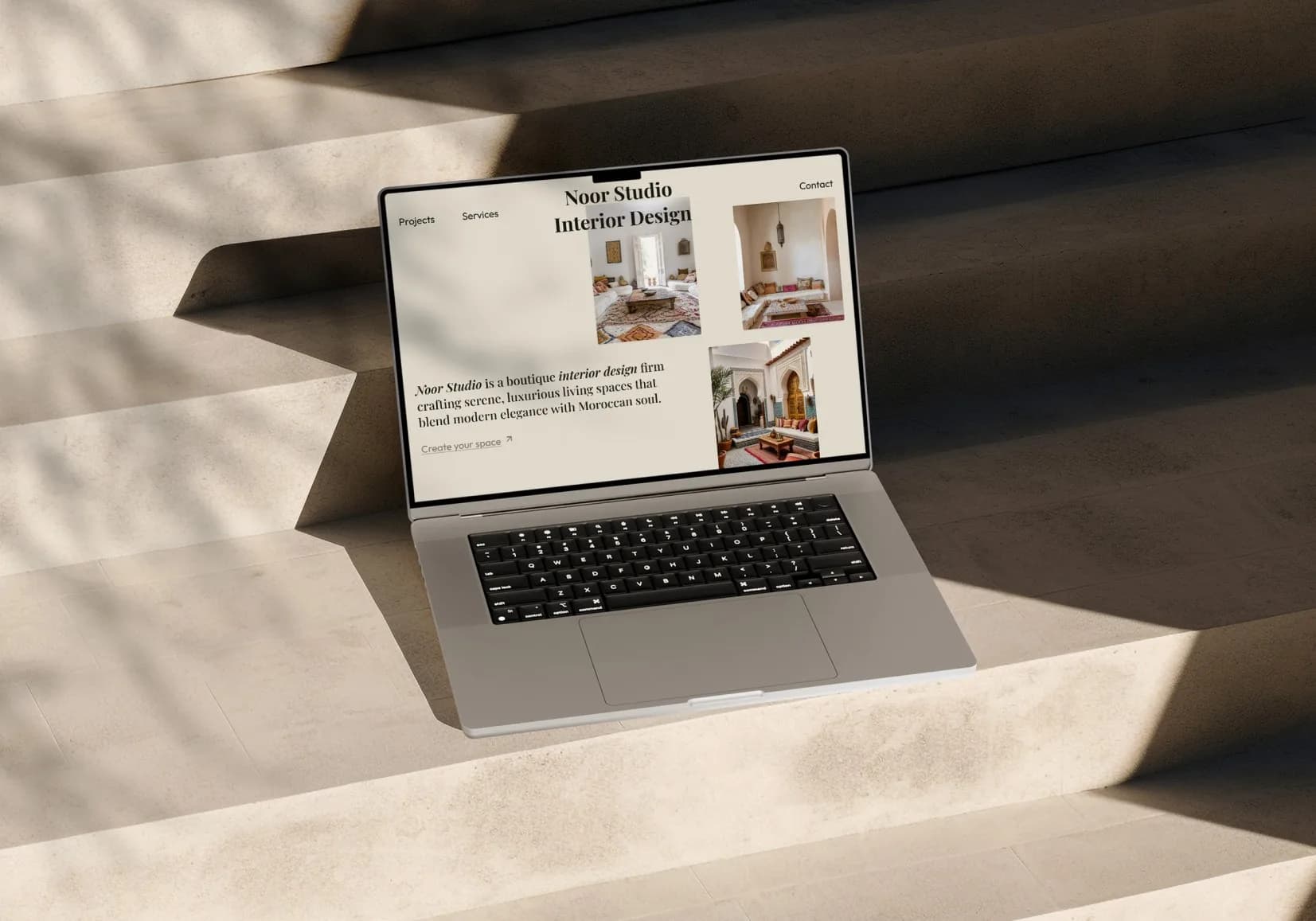 The Noor Studio site on a laptop, in hard Moroccan sunlight.